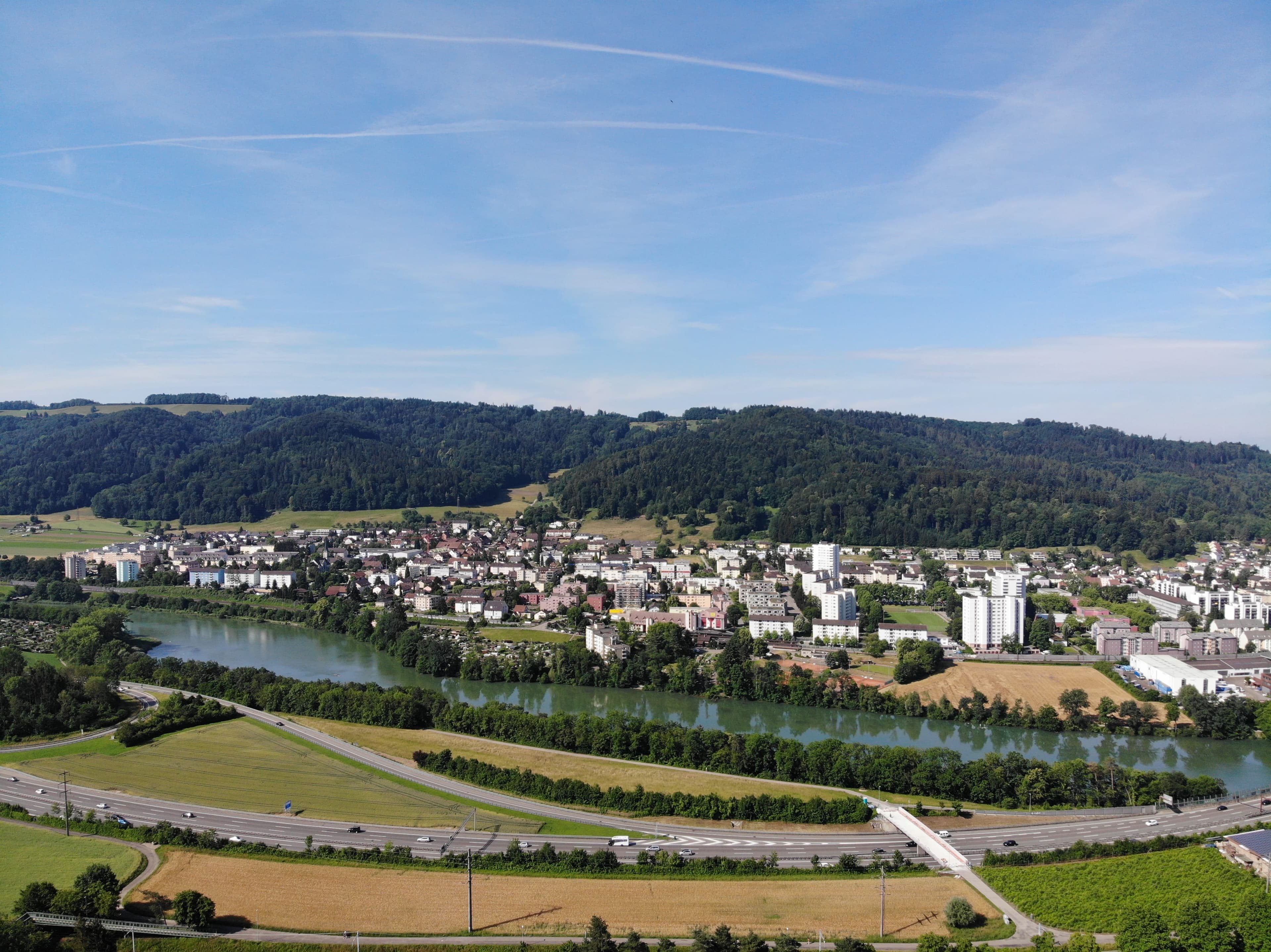 Luftaufnahme von Neuenhof mit Limmat und Bahnhof.